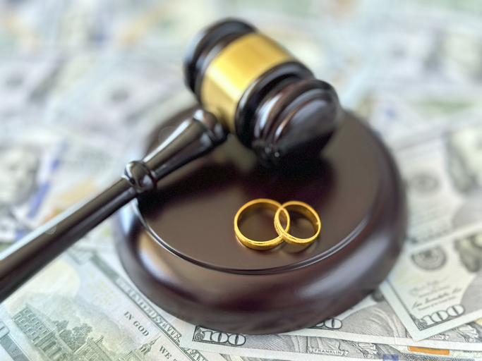 Rings and a gavel on top of cash
