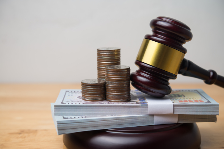 Gavel on top of stack of money and coins
