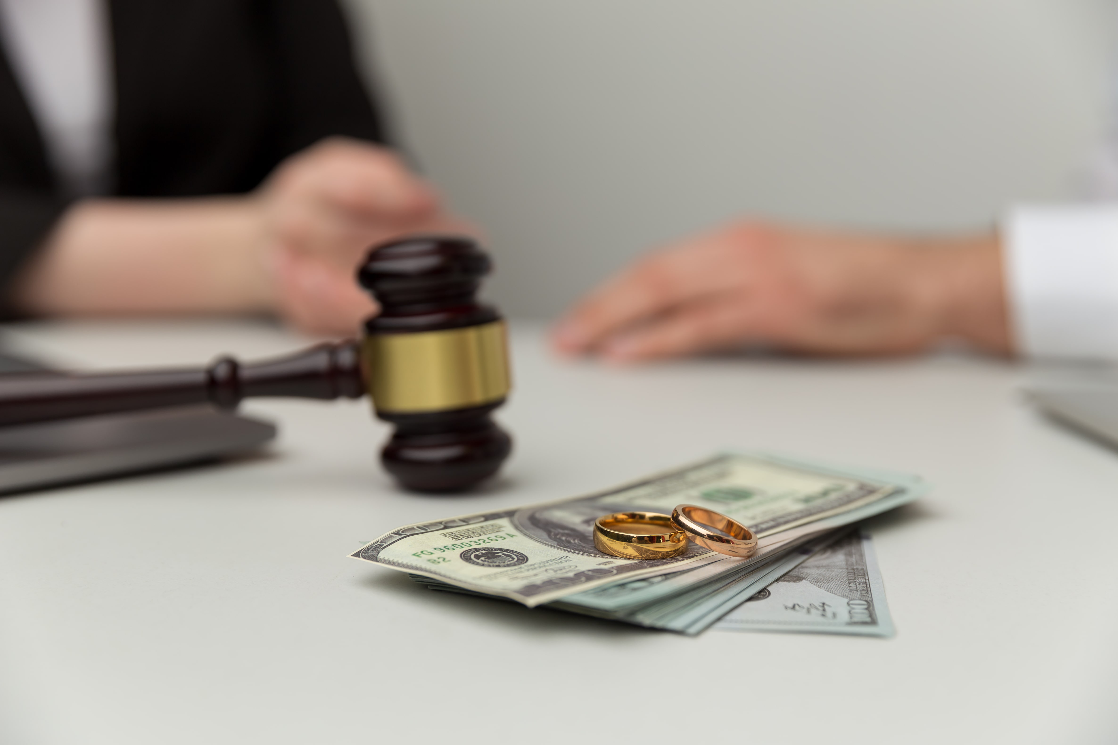 Gavel with hundred dollar bills and rings on top