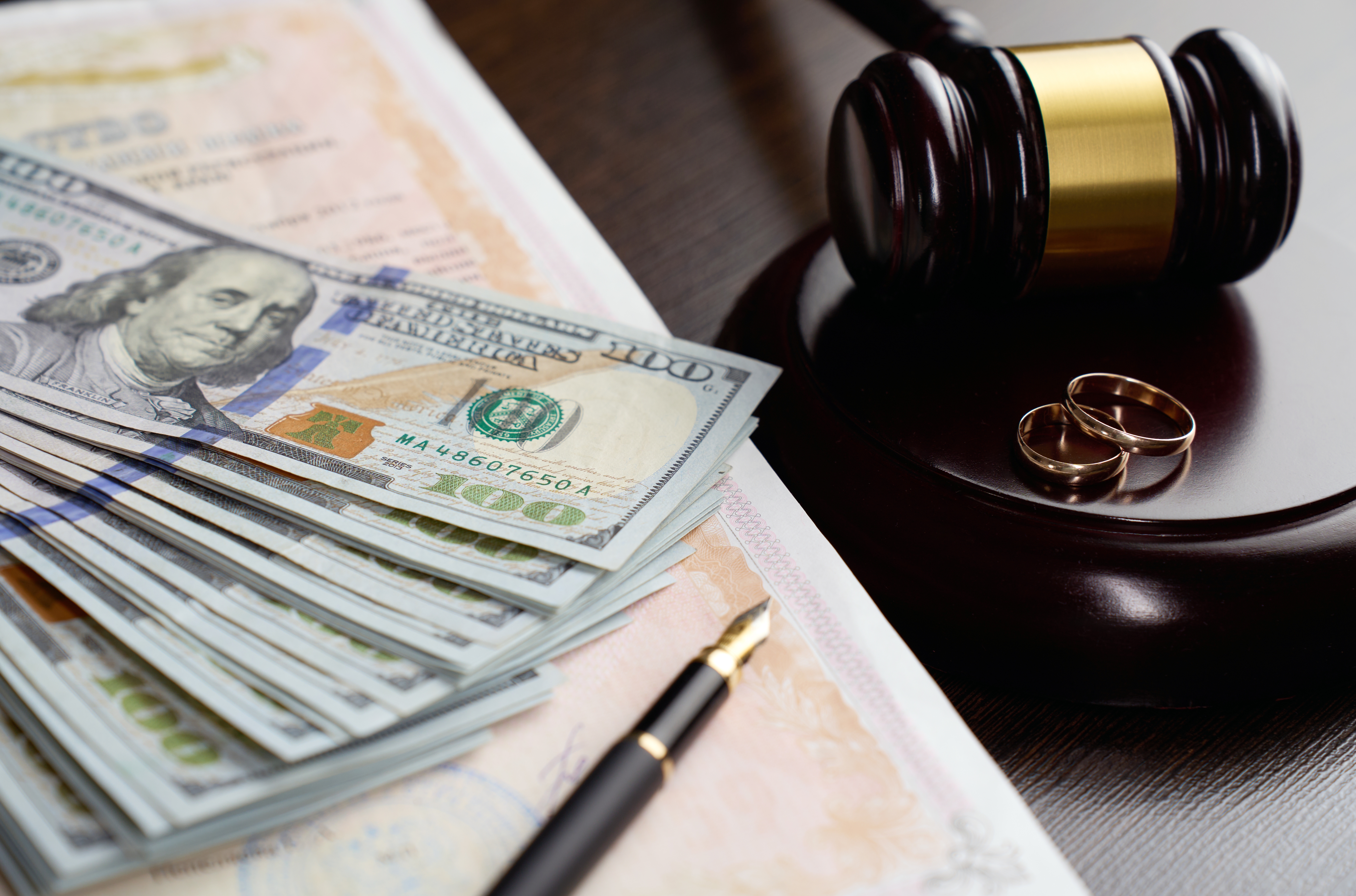 Gavel with wedding rings and money